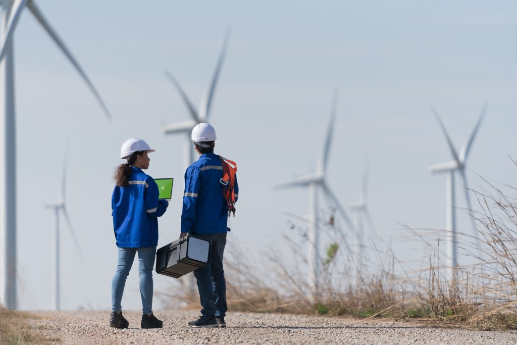 two workers view wind turbine