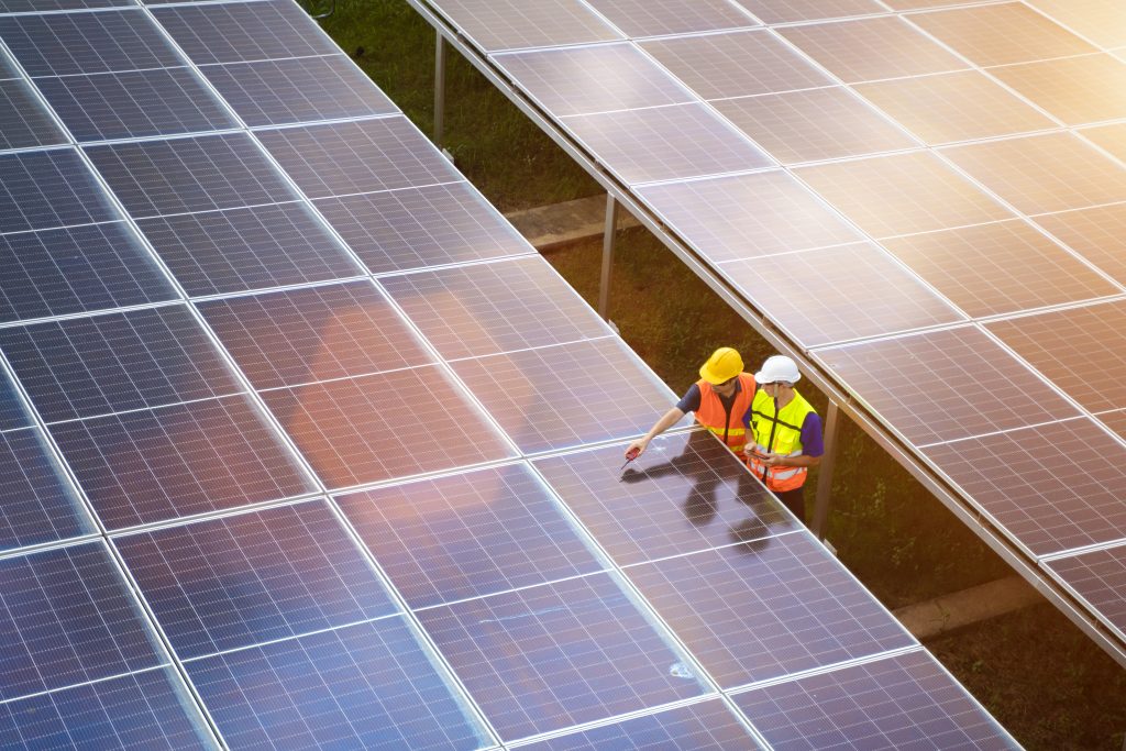 two workers look at solar panels